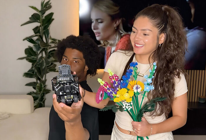 Couple enjoying creative at-home date night with flowers and a camera, showcasing fun and romantic ideas.