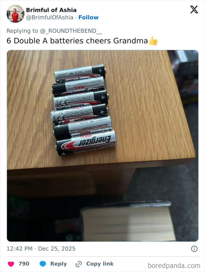 Six double A batteries laid out on a wooden table as one of the worst Xmas presents people received this holiday.