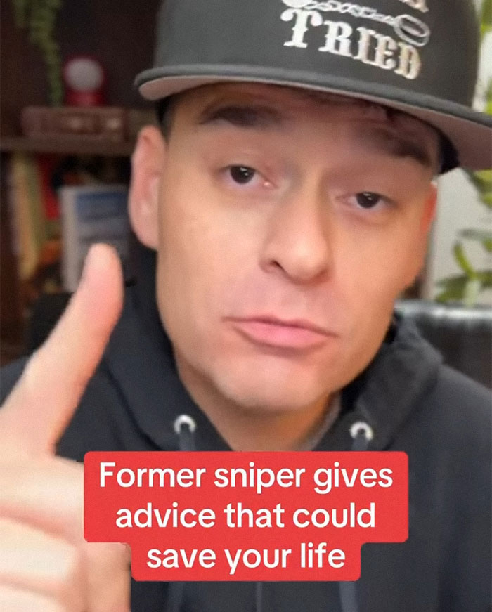 Man wearing cap and hoodie sharing mass shooting survival tips that could save your life in a close-up video frame.
