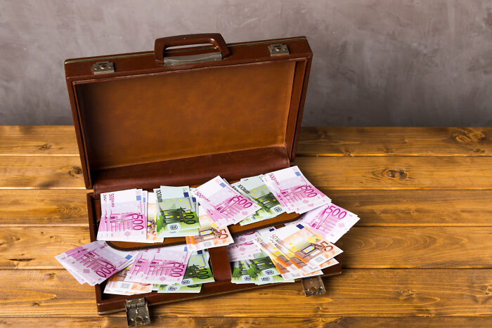Open briefcase filled with euro banknotes, illustrating unresolved mysteries people carry with them.