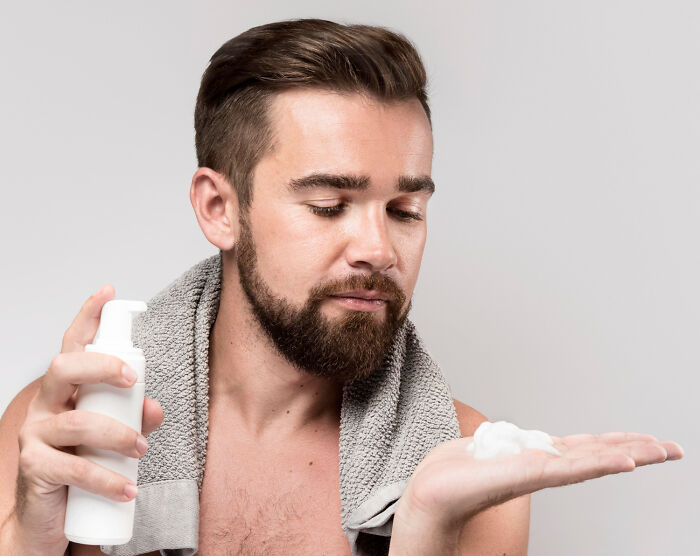 Man with towel applying foam, illustrating shocking secrets people trust strangers online with but keep private.