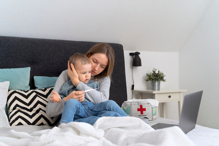 Mother comforting her sick child on bed, showing family drama and concern in a home setting with medical supplies nearby.