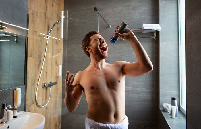 Man in bathroom pretending to sing into deodorant, one of the bizarre things seen through a neighbor’s window.