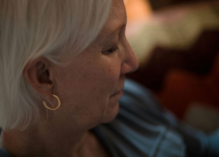 Close-up of an older woman with white hair and hoop earrings, reflecting the shocked reactions to unhinged MIL comments.