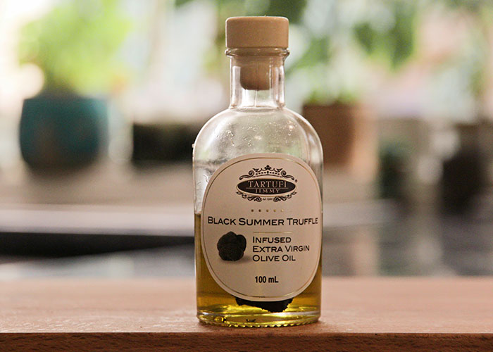 Bottle of luxury black summer truffle infused extra virgin olive oil, an example of rip-offs in luxury industries.