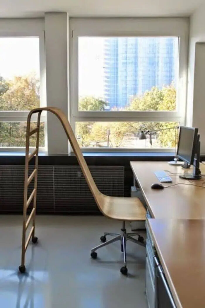 Wooden office chair with an extended backrest blending into a ladder in a bright room, showcasing trippy pictures concept.