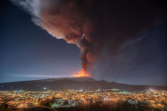 Volcanic eruption at night with lightning striking through smoke illustrating disturbing science facts.