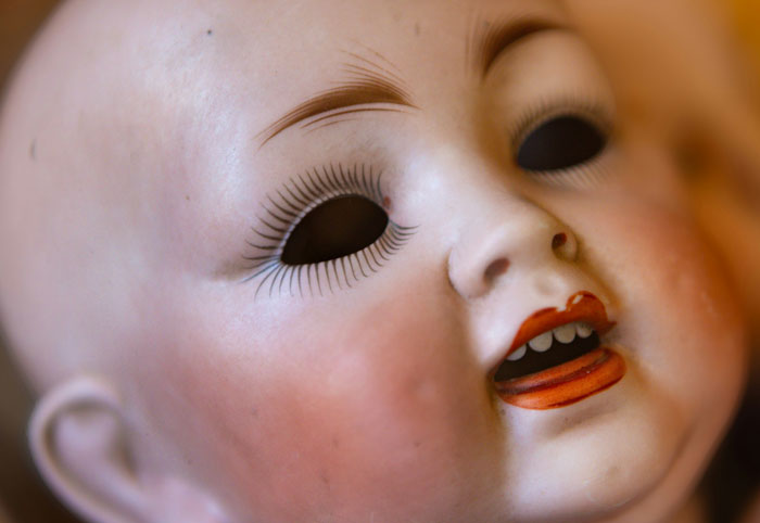 Close-up of a creepy doll with hollow eyes, evoking fear in people who couldn't sleep after time in the woods.