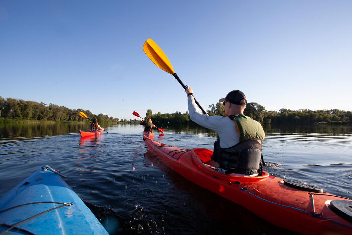 People kayaking on a calm lake, capturing everyday outdoor moments others were blessed to see unnoticed.