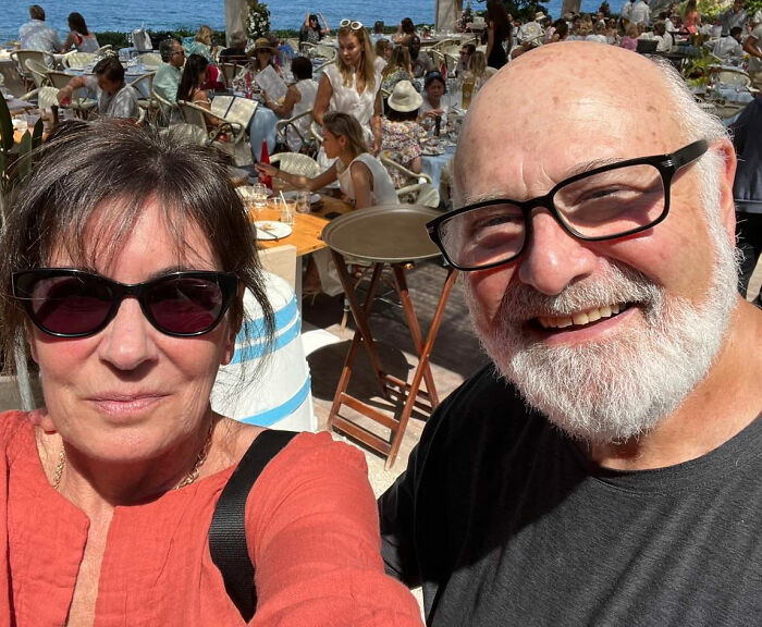 Rob Reiner&rsquo;s son Nick at an outdoor social gathering with people mingling and dining in the background.
