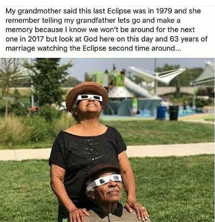 Elderly couple wearing eclipse glasses outdoors, sharing a sweet and wholesome moment during a solar eclipse.