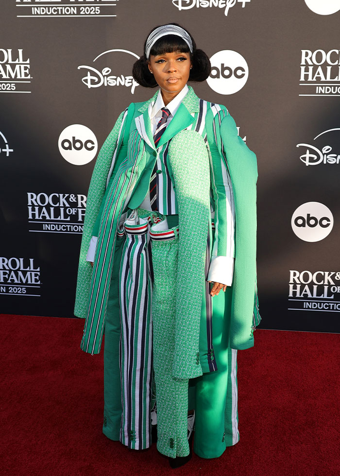 Celebrity in an oversized, multi-patterned green suit posing on the red carpet, showcasing 2025 fashion disasters.
