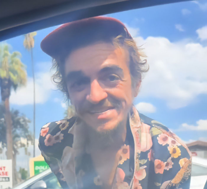 Nickelodeon star wearing a red cap and floral shirt, smiling outdoors in a video revealing homelessness struggle. Nickelodeon star wearing a red cap and floral shirt, smiling outdoors in a video revealing homelessness struggle.