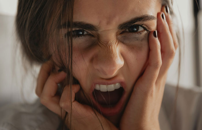 Woman expressing intense anger and frustration, capturing the emotion of repressed rage toward her MIL.