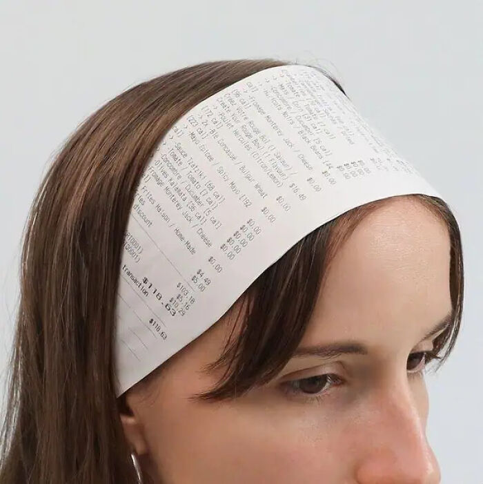 Woman wearing a headband made from a printed receipt, creating a trippy and surreal visual effect.