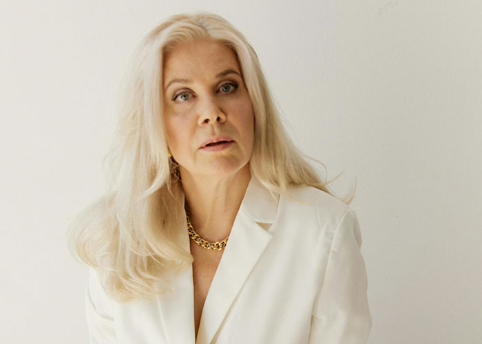 Older woman with long blonde hair dressed in white, portraying a shocked expression reflecting unhinged things a MIL said.