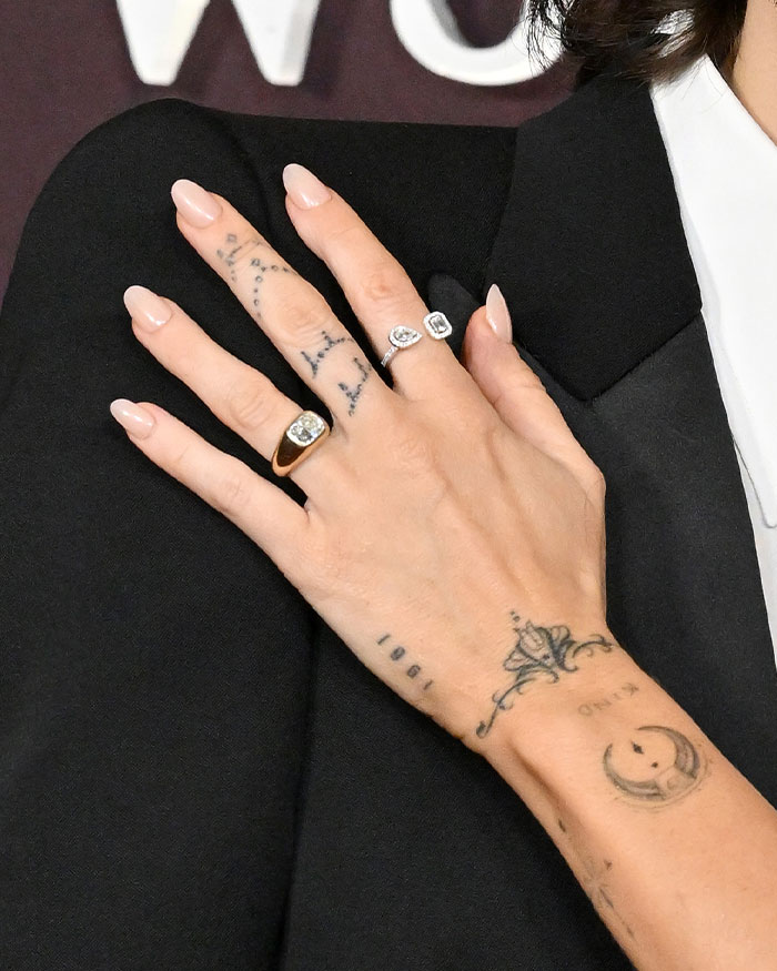 Close-up of hand with engagement rings and tattoos highlighting Miley Cyrus and Maxx Morando's engagement reaction. Close-up of hand with engagement rings and tattoos highlighting Miley Cyrus and Maxx Morando's engagement reaction.