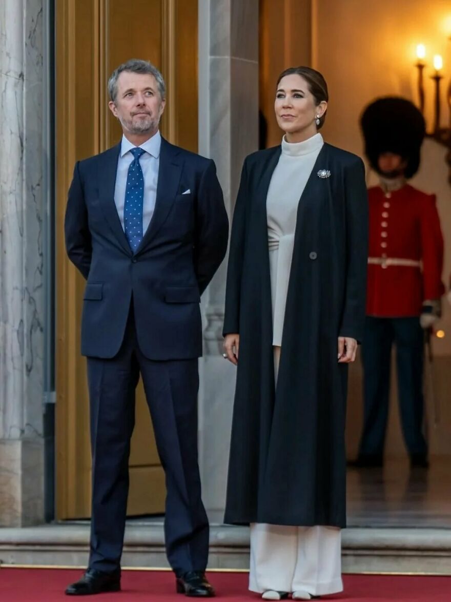 Dignified royal couple in formal attire standing on red carpet with a royal guard in the background, representing oldest surviving monarchies.