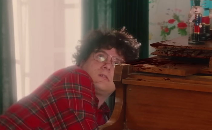 Man in red plaid shirt looking up, bloodied piano wood, scene from SNL Home Alone parody with Ariana Grande twist Man in red plaid shirt looking up, bloodied piano wood, scene from SNL Home Alone parody with Ariana Grande twist