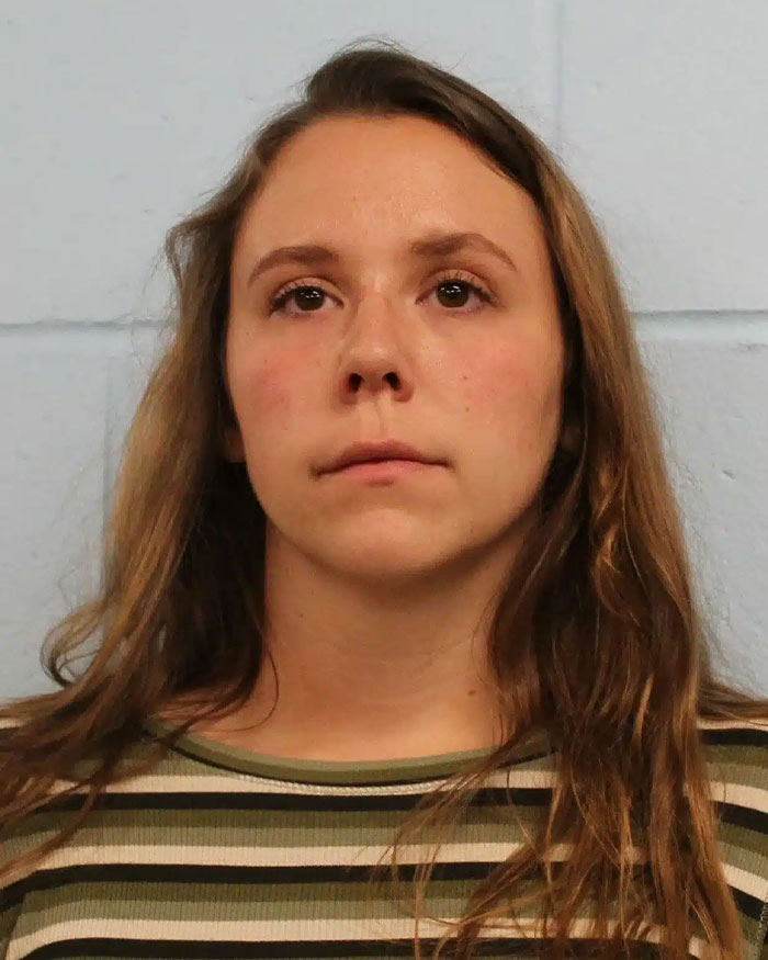 Woman appearing distressed in a mugshot photo related to an engaged teacher who sent 35K texts to student case.