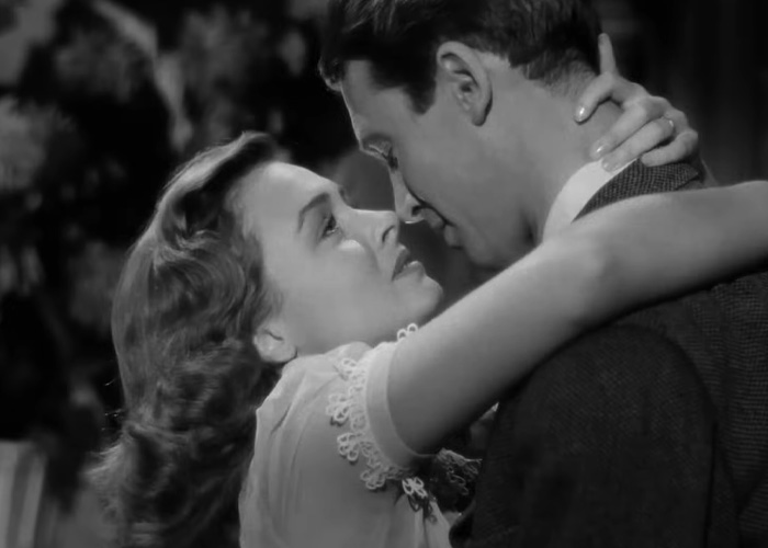 Black and white scene from a beloved Christmas classic showing a couple embracing in an emotional moment. Black and white scene from a beloved Christmas classic showing a couple embracing in an emotional moment.