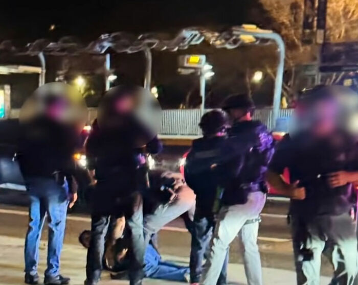 Law enforcement officers arresting Nick Reiner outside at night amid investigation into hotel room and Father Rob slaying. Law enforcement officers arresting Nick Reiner outside at night amid investigation into hotel room and Father Rob slaying.