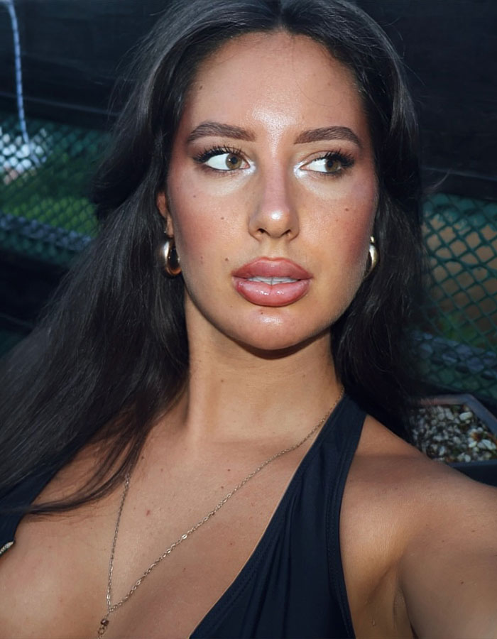 Young woman with dark hair and hoop earrings posing outdoors, first tennis star with breast enhancement now adult content creator. Young woman with dark hair and hoop earrings posing outdoors, first tennis star with breast enhancement now adult content creator.