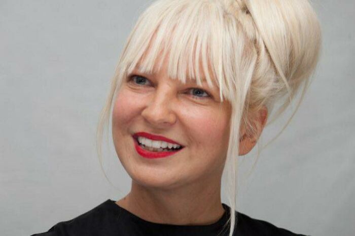 Sia celebrity with rare conditions, wearing a black top, showcasing the reality of living with uncommon health challenges.