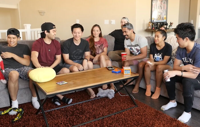 A group of friends sitting around a coffee table playing the best party game and enjoying their time together.