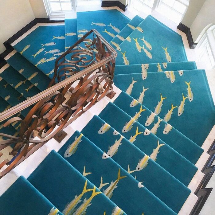 Blue staircase carpet with yellow fish design creating a trippy effect that seems plucked from another reality.