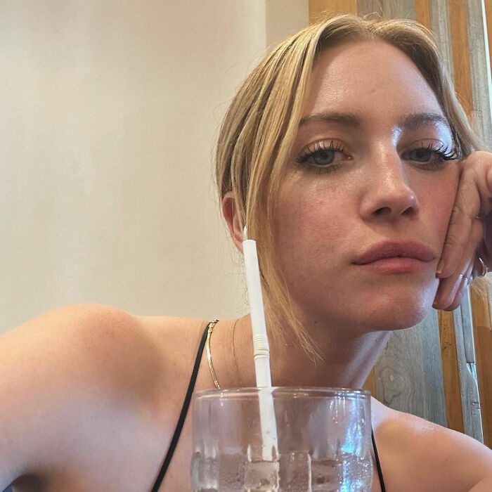 Britanny Snow with a neutral expression, resting her face on her hand near a glass with a straw, addressing plastic surgery rumors. Britanny Snow with a neutral expression, resting her face on her hand near a glass with a straw, addressing plastic surgery rumors.