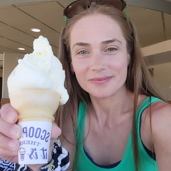 Woman in green tank top holding ice cream cone inside a shop, related to racist Cinnabon employee GoFundMe controversy. Woman in green tank top holding ice cream cone inside a shop, related to racist Cinnabon employee GoFundMe controversy.
