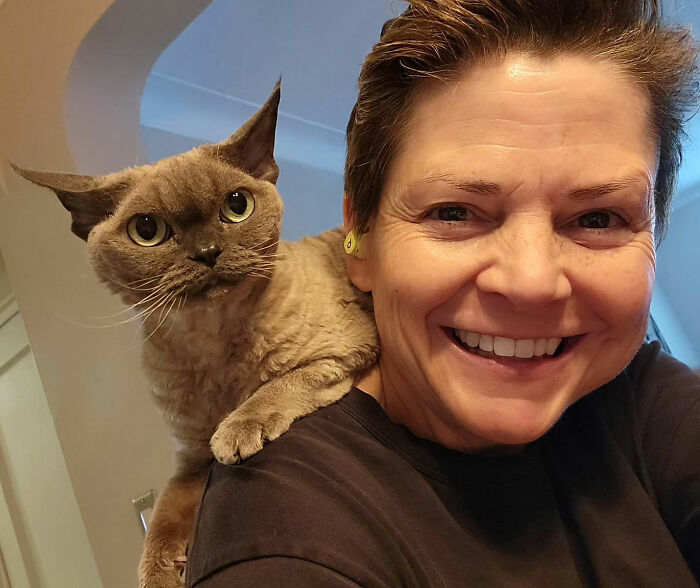 Close-up of a smiling woman with short hair and a cat on her shoulder, related to Marvelous Mrs. Maisel actress news. Close-up of a smiling woman with short hair and a cat on her shoulder, related to Marvelous Mrs. Maisel actress news.