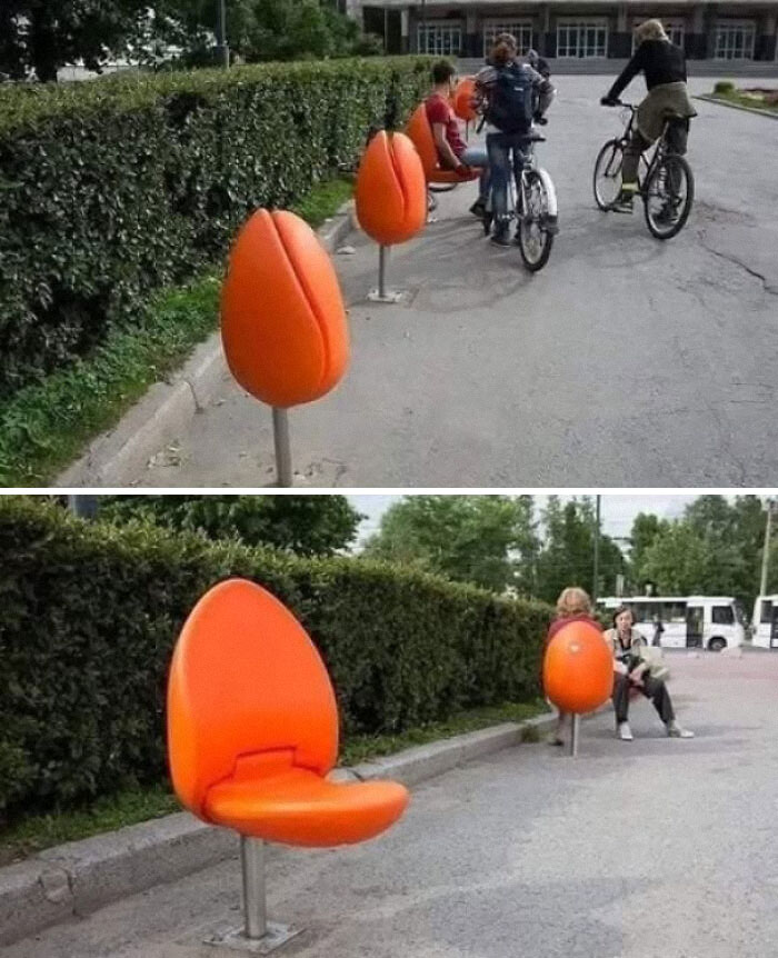 Orange tulip-shaped benches on a sidewalk with people sitting and biking, illustrating creative existence and reality concepts.