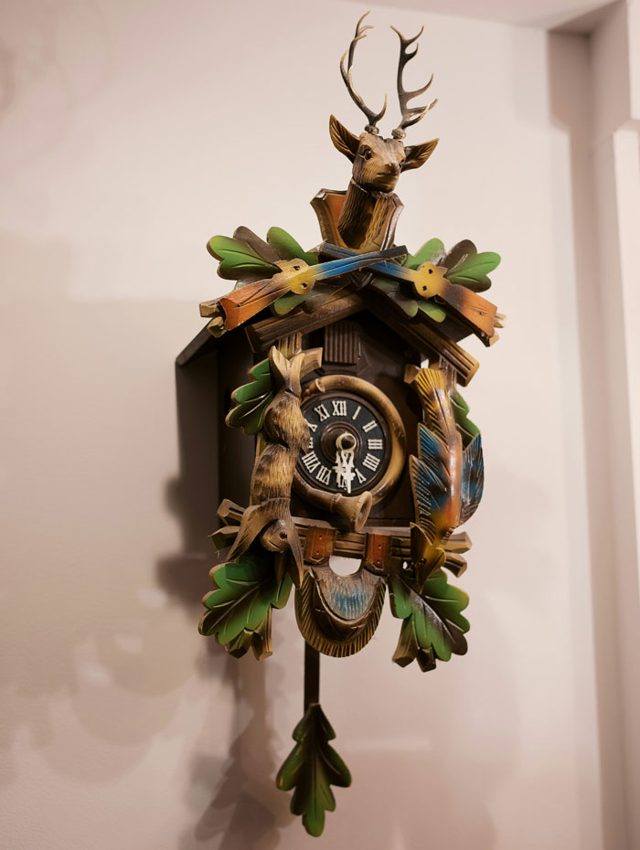 Wooden cuckoo clock with deer and bird carvings, a unique white elephant gift that everyone tried to steal.