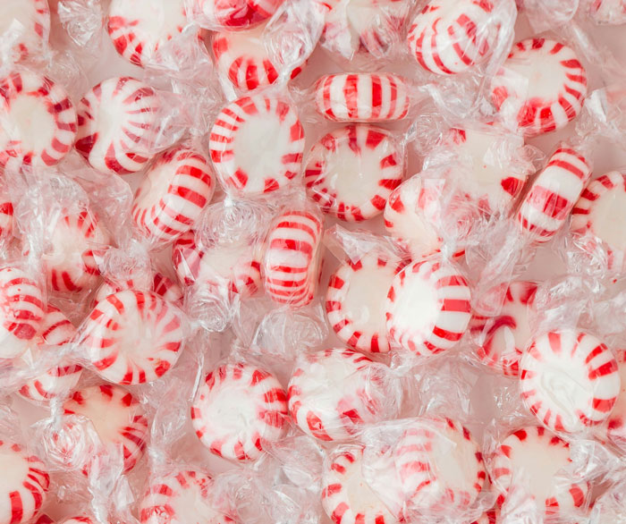 Close-up of red and white peppermint candies wrapped in clear plastic, perfect for white elephant gifts.