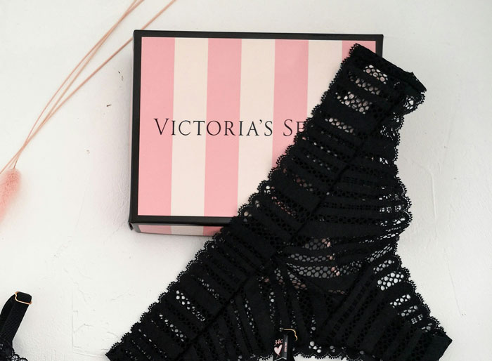 Pink striped Victoria's Secret gift box with black lace lingerie, perfect white elephant gifts that everyone tried to steal.