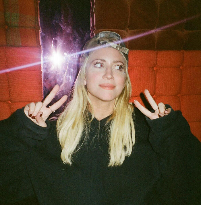 Britanny Snow posing indoors with peace signs, wearing a black hoodie and a cap, addressing plastic surgery rumors. Britanny Snow posing indoors with peace signs, wearing a black hoodie and a cap, addressing plastic surgery rumors.