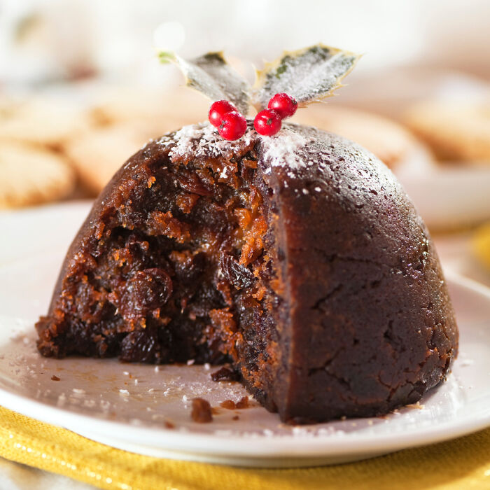 Rich and moist Christmas dessert with dried fruits and festive decoration, showcasing a delicious-looking holiday treat.