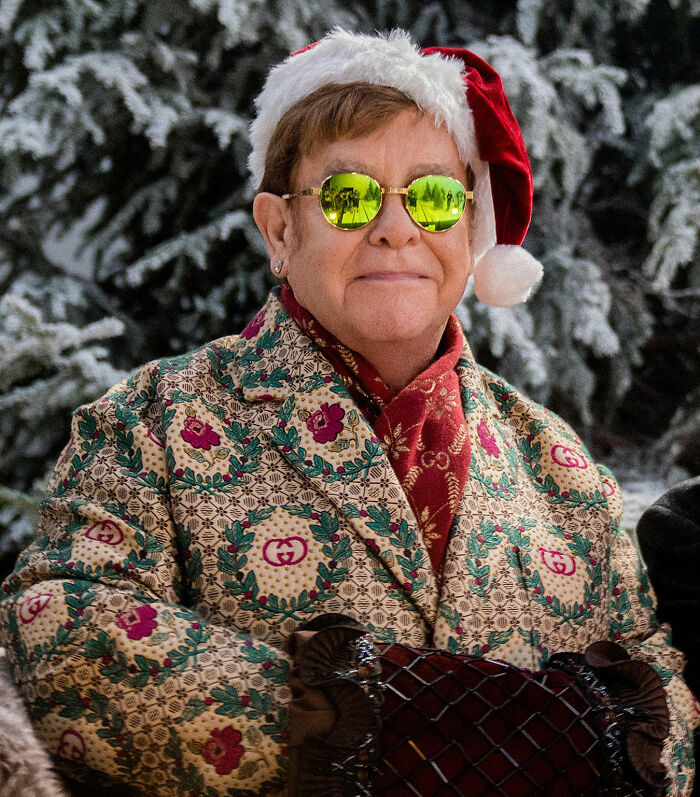 Elton John wearing festive attire and sunglasses outside in a snowy setting, reacting to fans about his kitchen detail. Elton John wearing festive attire and sunglasses outside in a snowy setting, reacting to fans about his kitchen detail.