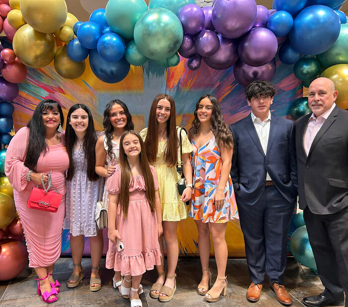 Group of well-dressed people standing under colorful balloons, related to trans instructor ousted after gender essay dispute.