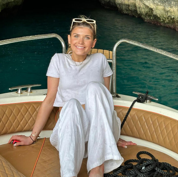 Young sorority girl smiling on a boat near crystal blue water, capturing a serene moment before tragic Christmas Eve accident.