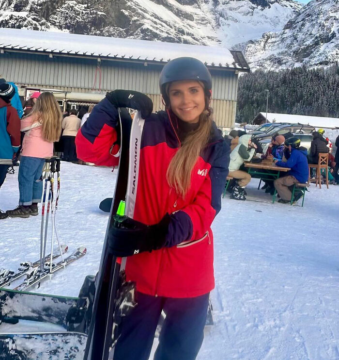 Young woman in ski gear holding skis outdoors at snowy mountain resort, related to sorority girl tragic accident news. Young woman in ski gear holding skis outdoors at snowy mountain resort, related to sorority girl tragic accident news.