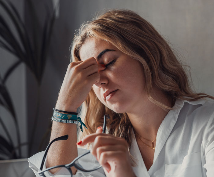 Woman holding glasses and rubbing her forehead looking stressed after women ruin MIL’s surprise event. Woman holding glasses and rubbing her forehead looking stressed after women ruin MIL’s surprise event.
