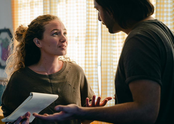 Woman hosting casual Christmas talks with man while dealing with toxic mother-in-law conflict indoors near window light. Woman hosting casual Christmas talks with man while dealing with toxic mother-in-law conflict indoors near window light.