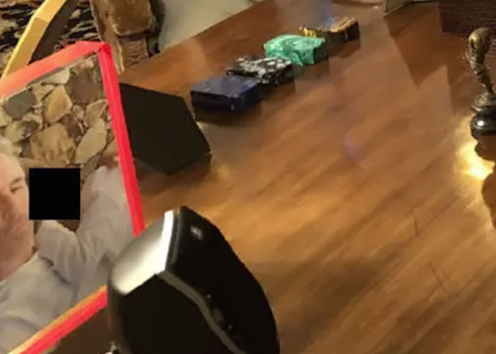 Disturbing Epstein desk photo showing personal items and reflections on wooden surface after Congress estate image release.