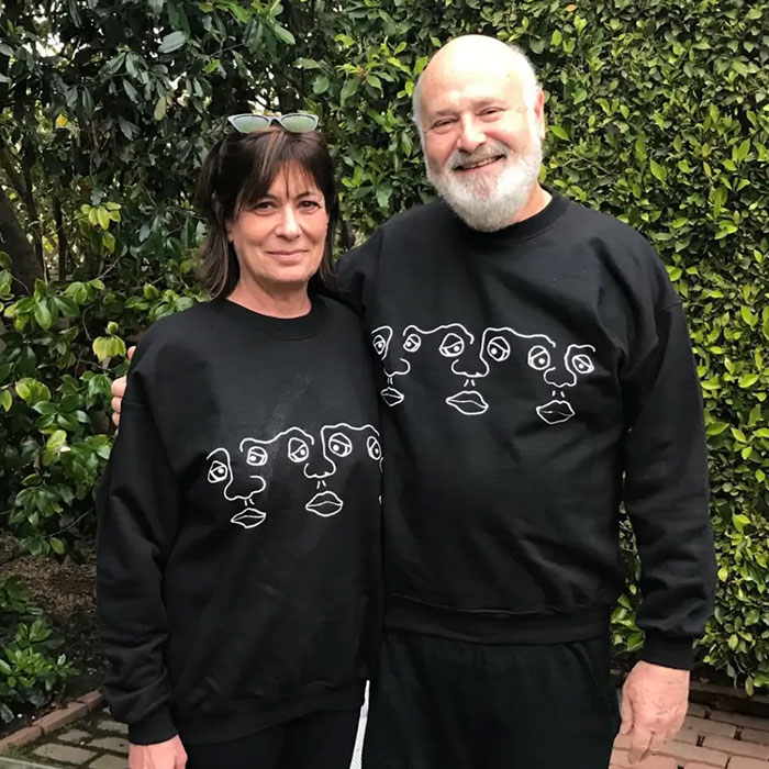 Couple standing outdoors in matching black sweatshirts, related to Rob Reiner&rsquo;s son arrested for allegedly slaying parents.