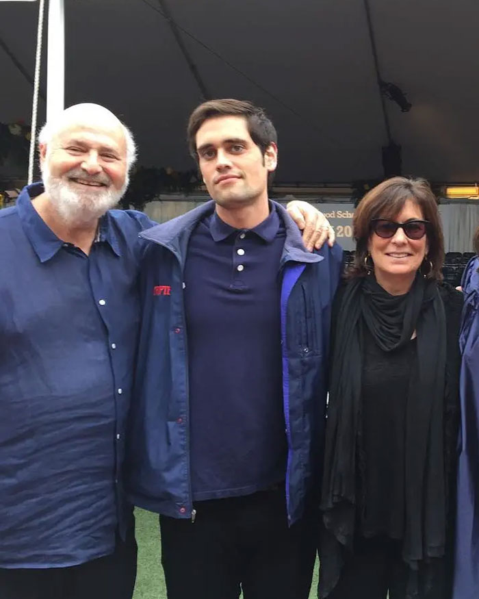 Rob Reiner and son Nick standing together outdoors, casually dressed, at a social gathering. Rob Reiner and son Nick standing together outdoors, casually dressed, at a social gathering.