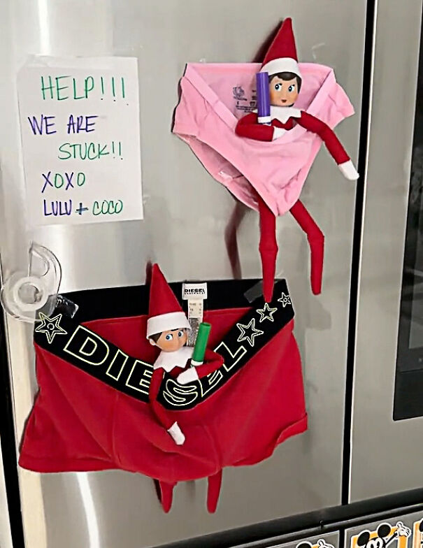 Two Elf On The Shelf dolls stuck in underwear on a fridge with a handwritten note asking for help.