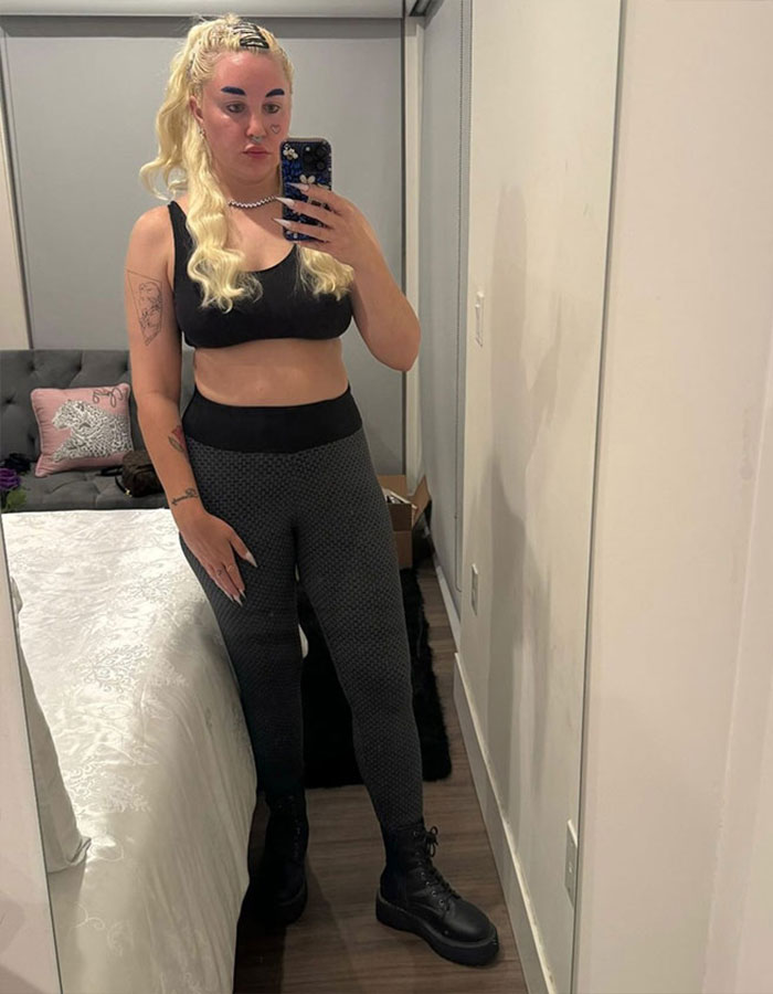 Amanda Bynes taking a mirror selfie wearing black workout clothes, showing dramatic weight loss after injections discussion.